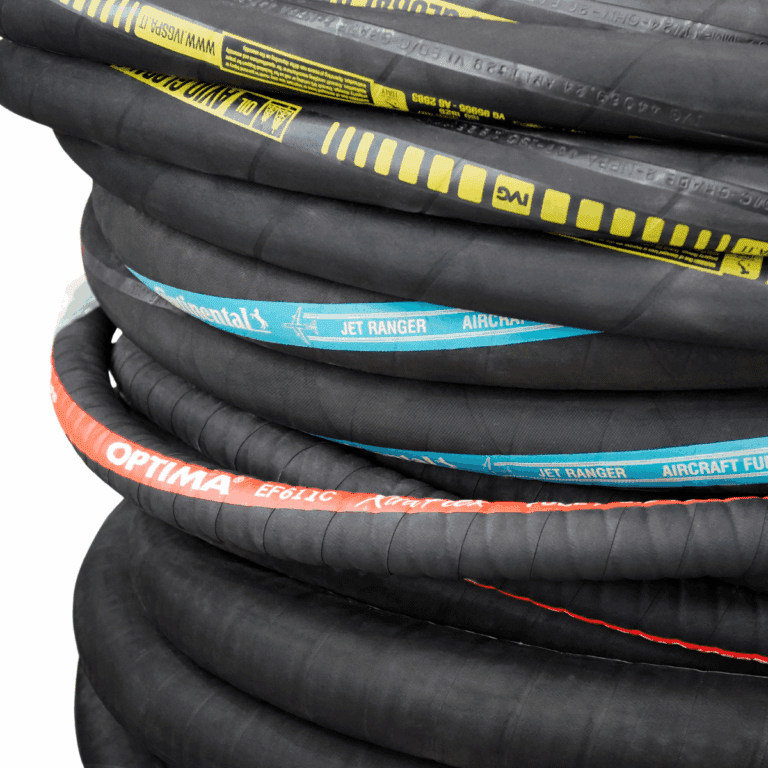 A close-up of several coiled black industrial hoses stacked on top of each other, each labeled with different colored text such as yellow, blue, and red brand names and specifications.